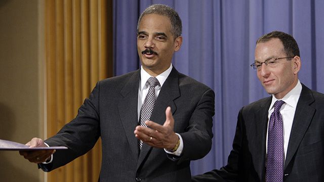 Attorney General Eric Holder, left, gestures to the media with Assistant Attorney General Lanny Breuer during a news conference at the Department of Justice in Washington, Wednesday, Dec. 16, 2009. Credit Suisse Group has agreed to pay $536 million to settle a Justice Department probe and admit to violating U.S. economic sanctions by hiding the booming illegal business it was doing for Iranian banks. (AP Photo/Alex Brandon)