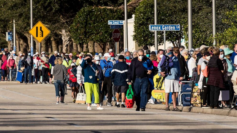 PHOTO: Hundreds of people wait in line at Lakes Park Regional Library to receive the COVID-19 vaccine in Fort Myers, Fla., Dec. 30, 2020.