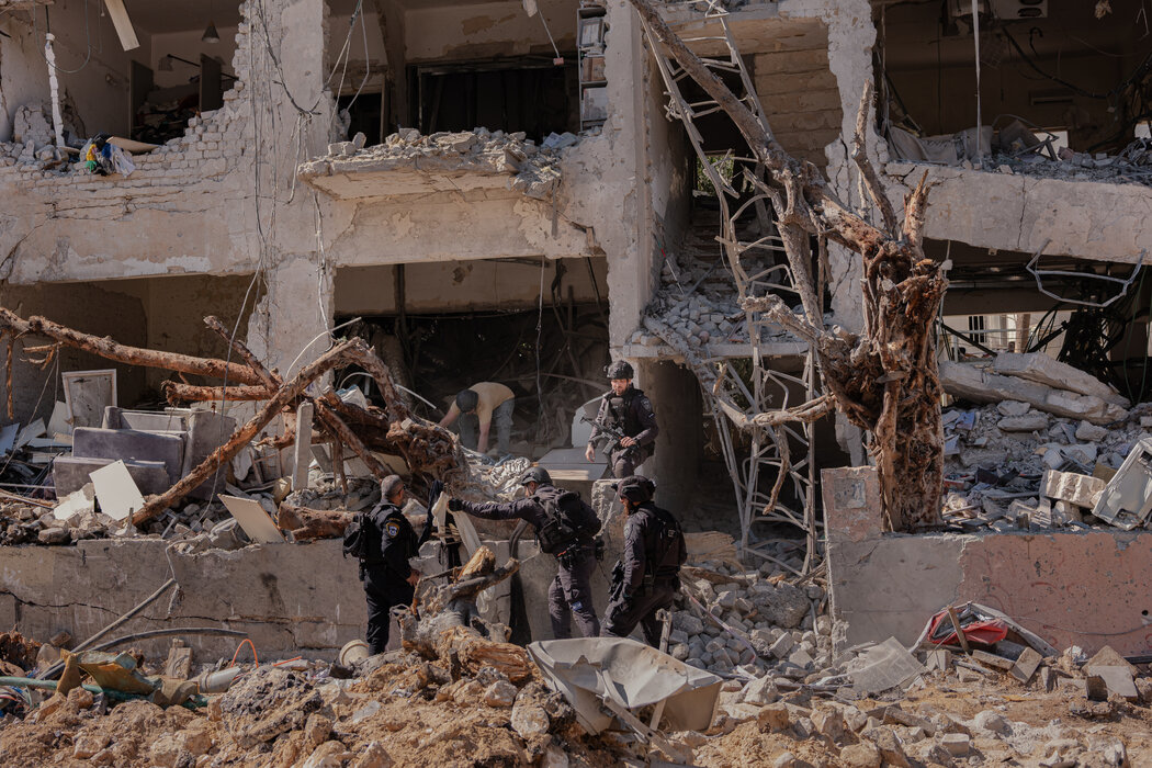 周日，以色列安全官员在检查特拉维夫一栋遭伊朗袭击损毁的建筑。