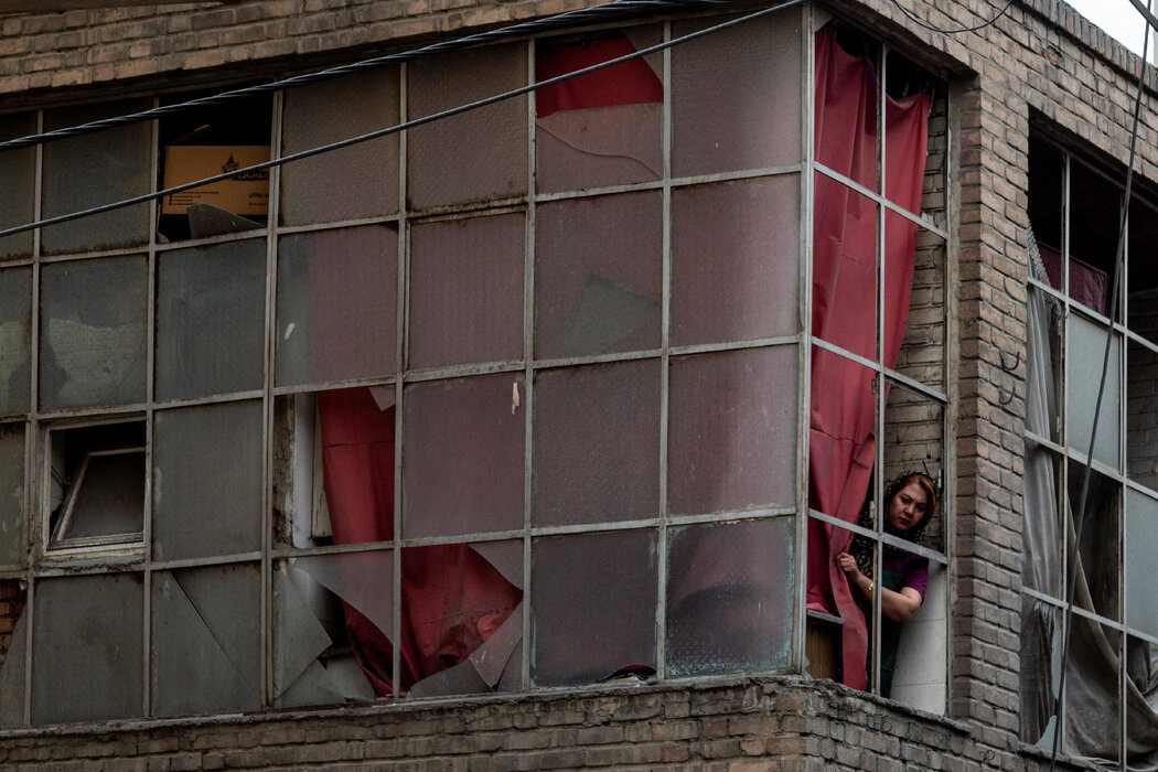 周五,一名女子从德黑兰一栋受损的建筑物里向外张望。