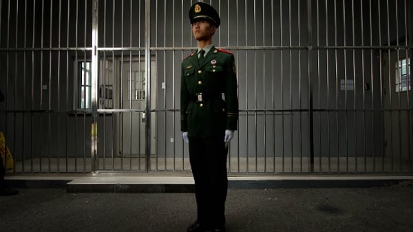2012年10月25日，在北京的一次政府组织参观活动中，一名准军事警卫站在第一看守所正门铁栅栏前。这座可容纳1000名在押人员的设施罕见地向外国媒体开放参观。（图片来源：Ed Jones/AFP via Getty Images）