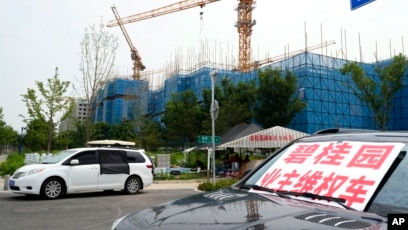 2023年8月17日，在北京郊区正在建设中的碧桂园·和世界项目附近，一辆挂着“碧桂园业主维权车”标语的汽车停在业主们露营的地方。此前，这家大型房地产开发商未能偿还数千亿人民币的债务，引发了人们对房地产行业财务状况不稳定及其对举步维艰的中国经济影响的担忧。